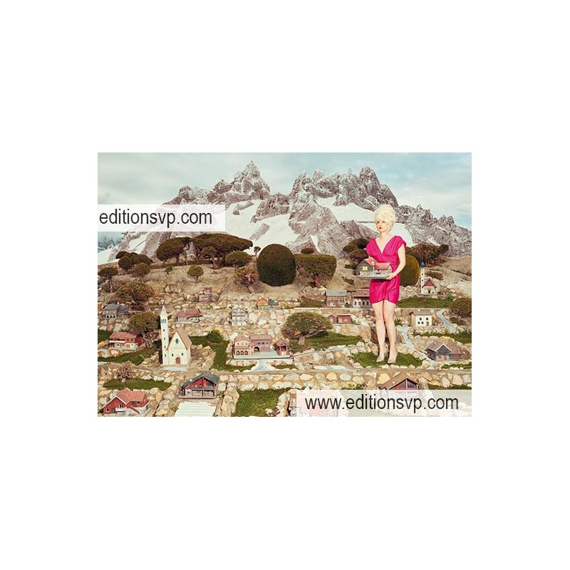 Les Alpes en miniaturie, une femme blonde porte une maison dans ses mains